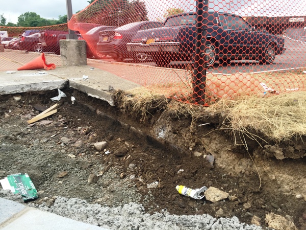 At the temporary construction entrance from Central Ave. From under a sidewalk construction workers have uncovered what is assumed to be the 1913 curb line. 8-14-15 [PHOTO: NYSDOT]